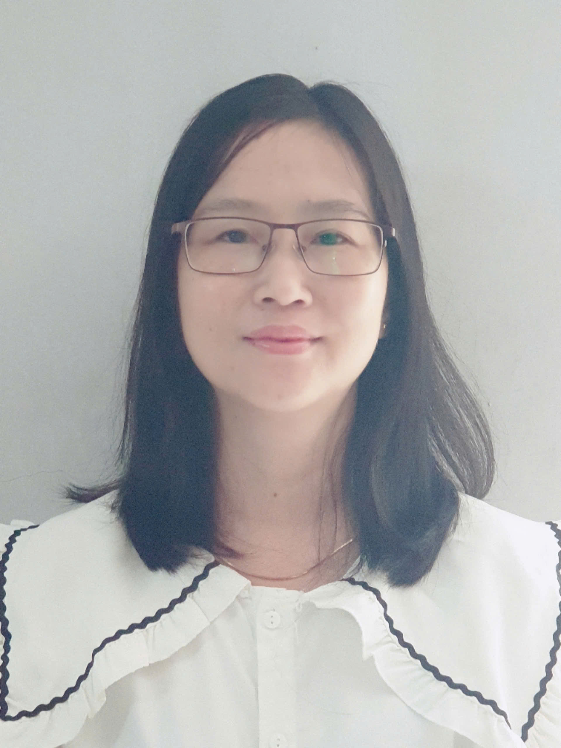 A person with glasses smiling Description automatically generated